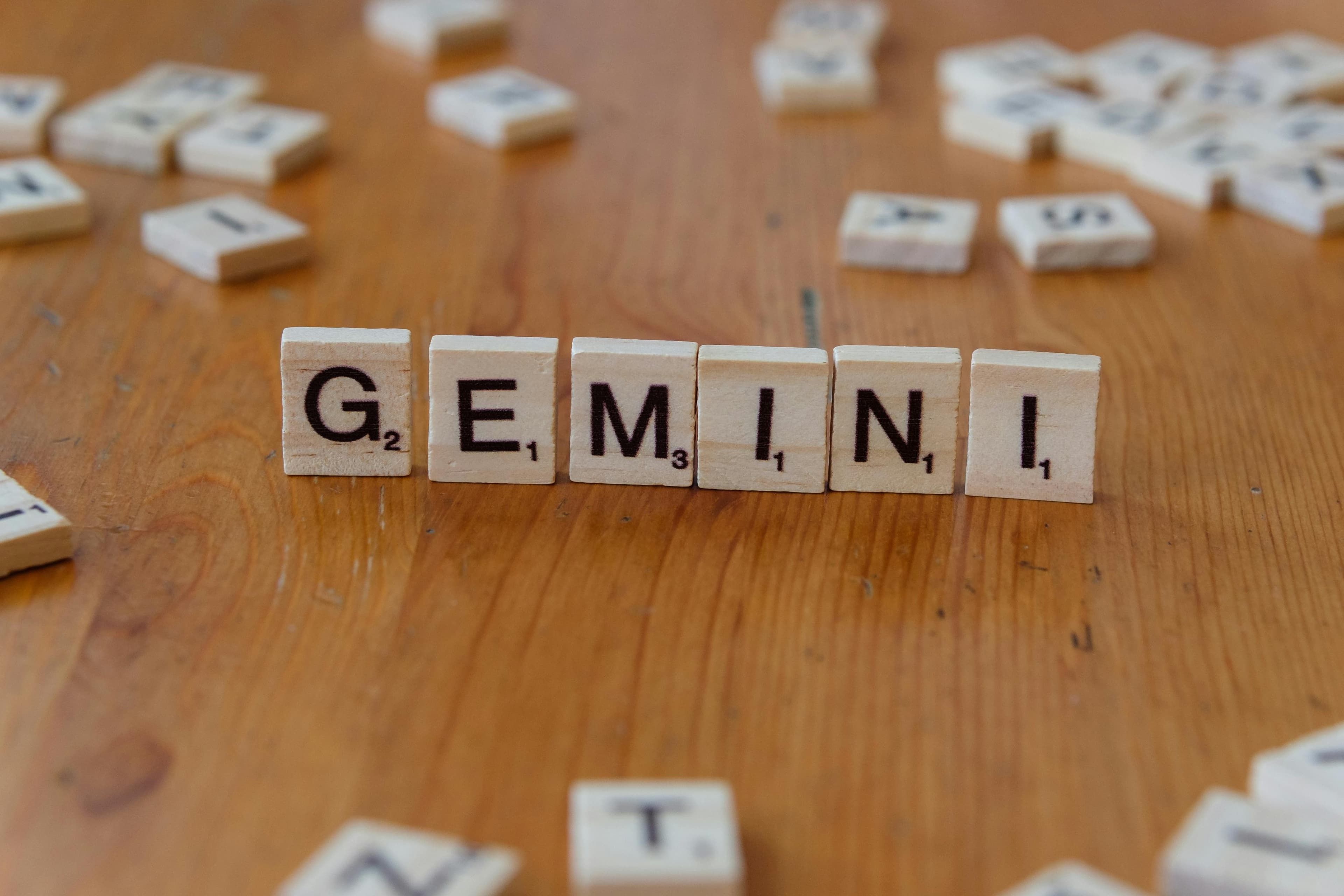 Gemini zodiac sign spelled with Scrabble tiles on a wooden table